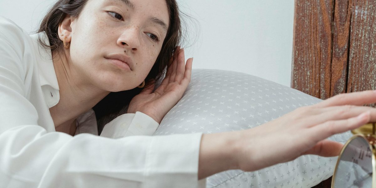 A person lying in bed, experiencing a racing mind and difficulty falling asleep due to anxiety.