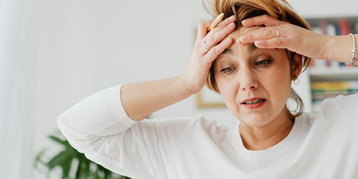 A person exhibiting signs of stress or anxiety, conveying the feeling of overwhelm described in the article.