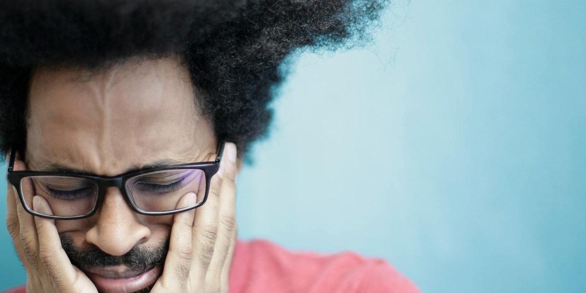 A person expresses worry while preparing to measure blood pressure, highlighting the anxiety often associated with health monitoring.