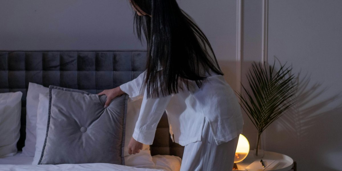 A person dimming lights and preparing their room for sleep, illustrating the importance of environmental factors.