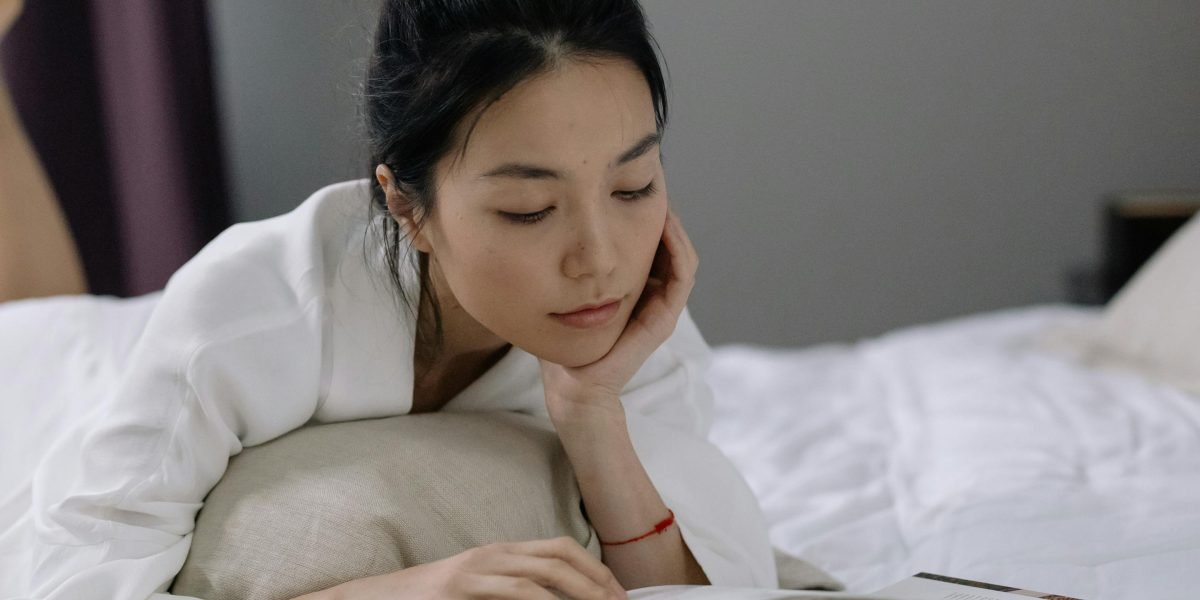 A person comfortably lying in bed, practicing a guided sleep meditation before drifting off to sleep.
