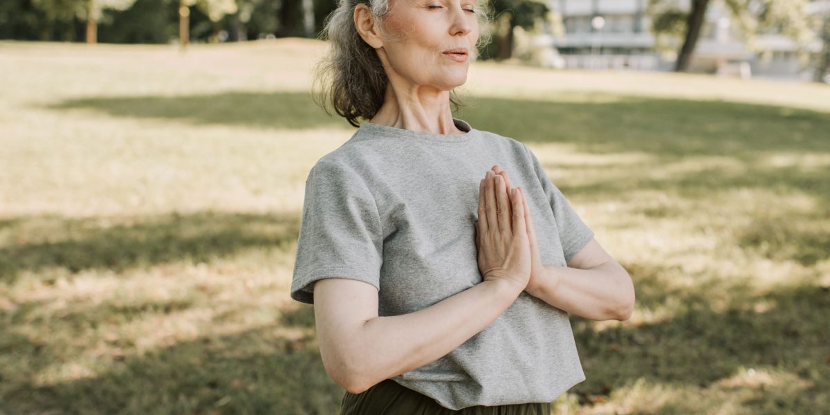 An individual engaging in a relaxation technique like deep breathing or meditation, enhanced by background sleep sounds.