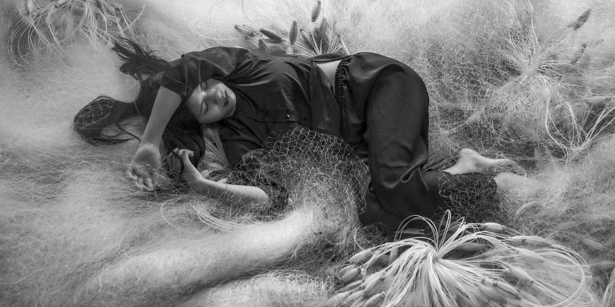 A person lies awake in bed, experiencing the common struggle of sleep anxiety and racing thoughts.